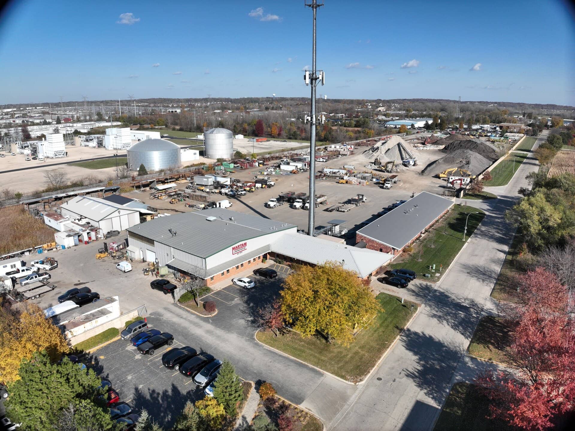 Construction supply store with parking lot and industrial buildings.